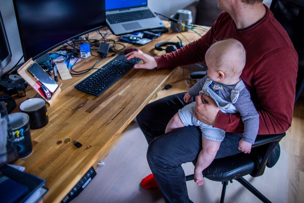 Hombre teletrabajando con su bebé