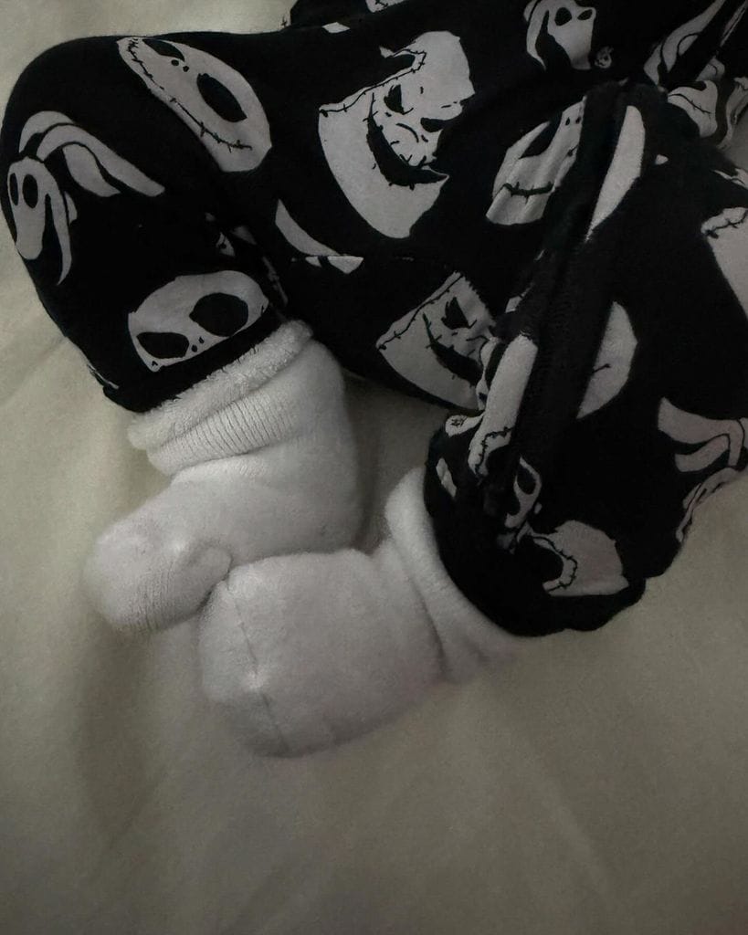 Primer plano de los pies del bebe de Hailey Bieber con pijama de halloween