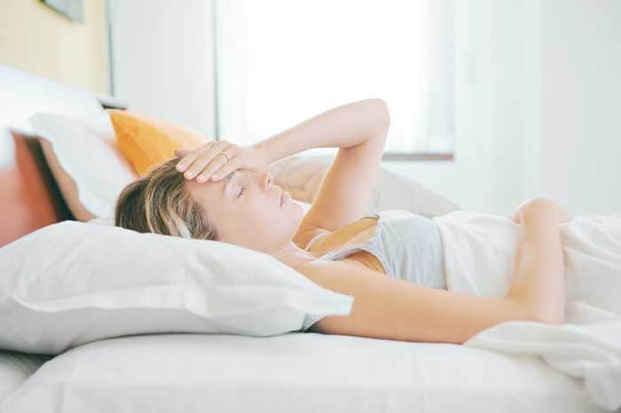 mujer con malestar en la cama