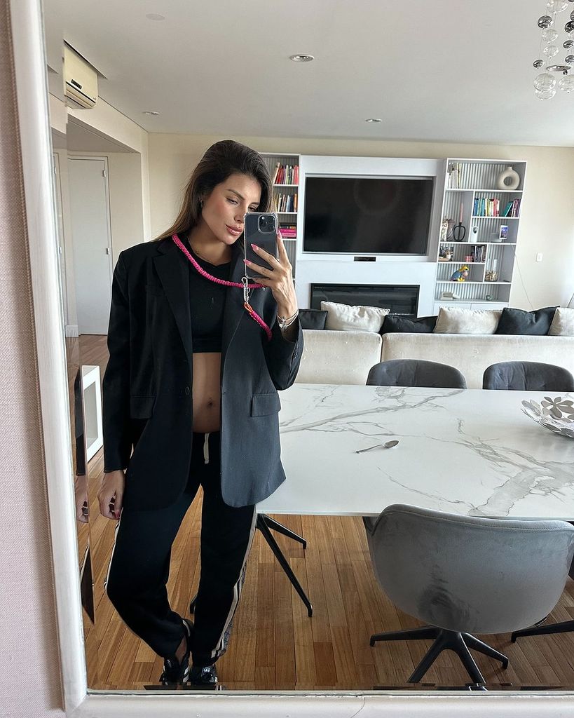 Plano entero de Magali Aravena en en el espejo con blazer y chandal