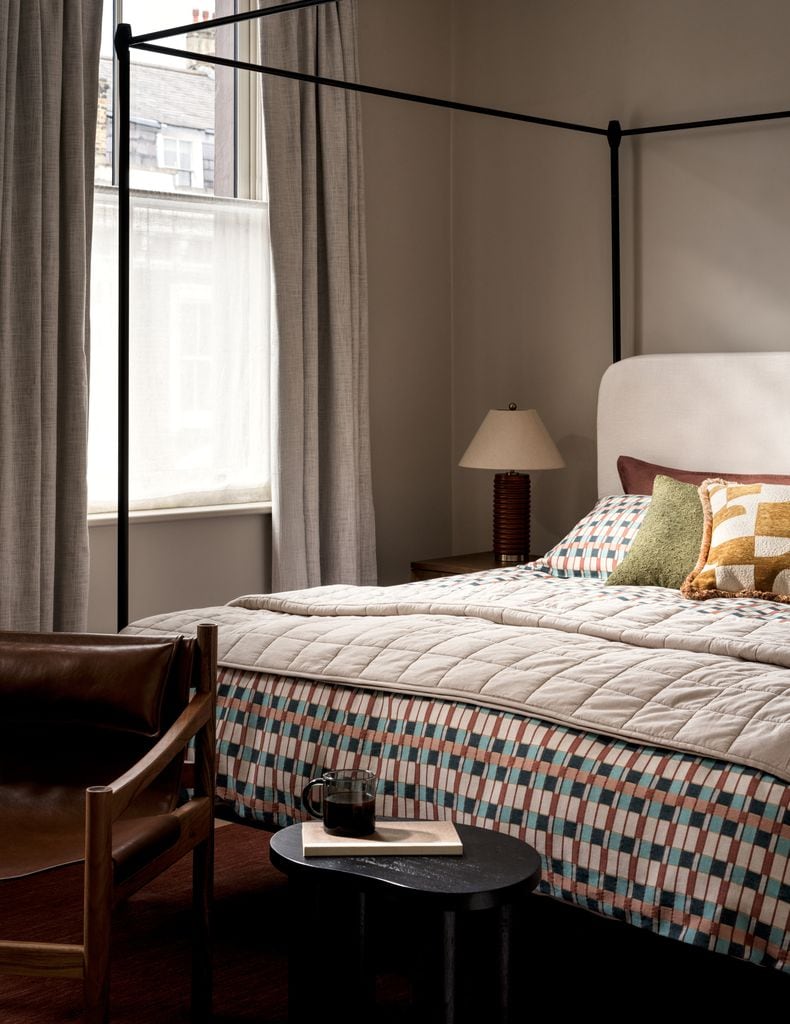 Dormitorio con cama con dosel y textiles geométricos