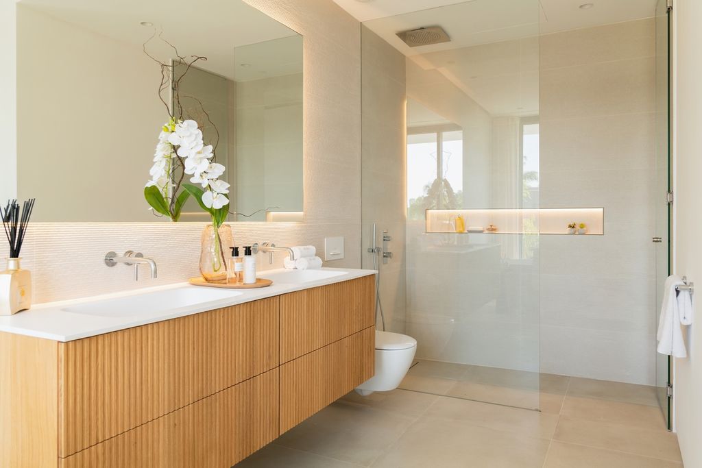 Baño de líneas modernas y depuradas, un espacio para compartir con dos lavamanos integrados en la encimera