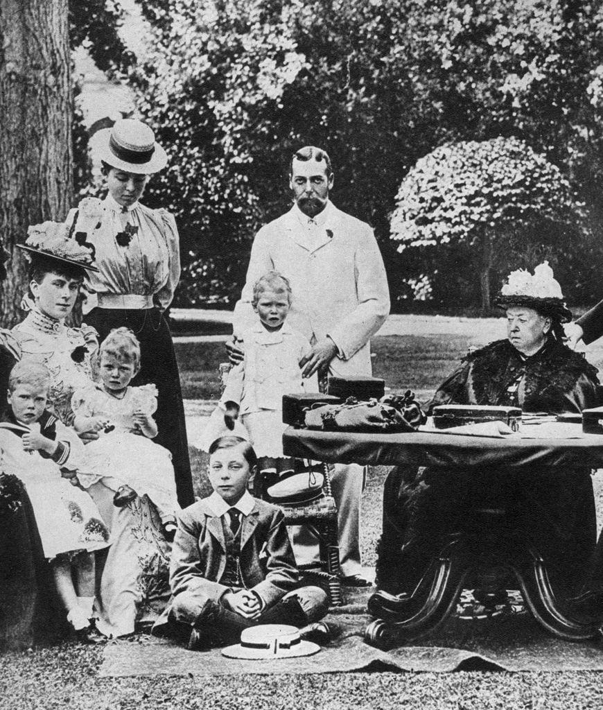La reina Victoria y su familia en Osborne House, a finales del siglo XIX. El príncipe Eduardo, duque de Windsor (el futuro Eduardo VIII que dejó la corona para casarse con Wallis Simpson), aparece en primer término sentado en el suelo. Mary de Teck, la esposa del príncipe Jorge, sostiene a la Princesa Real en su regazo y el que está al lado posiblemente sea el príncipe Jorge de Kent; detrás de ella está la princesa Margarita de Connaught. El príncipe de Gales (el futuro Jorge V) en pie sostiene al duque de York, el que con el tiempo se convertirá en el rey Jorge VI y padre de Isabel II, el abuelo del actual Carlos III.
