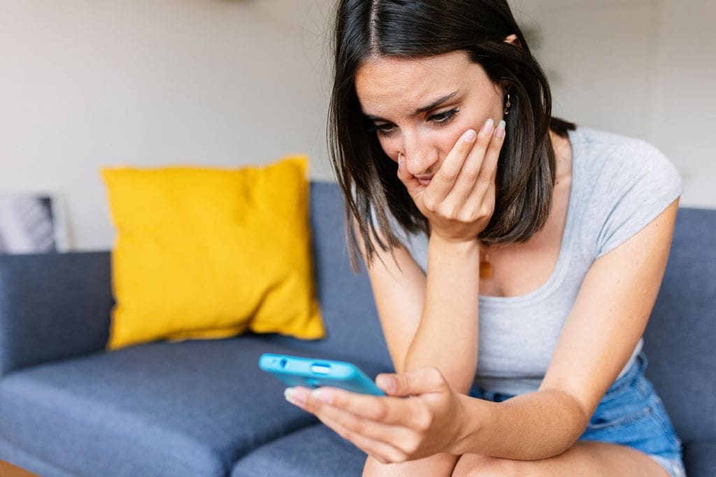 Mujer mirando el móvil preocupada 