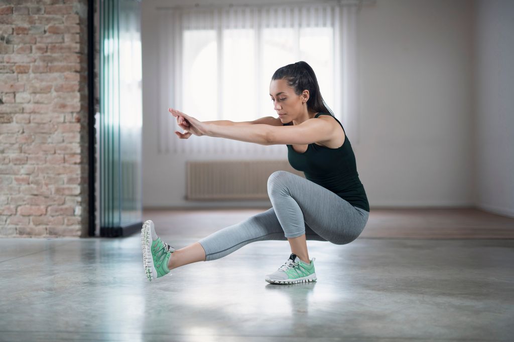 Mujer haciendo una sentadilla pistol