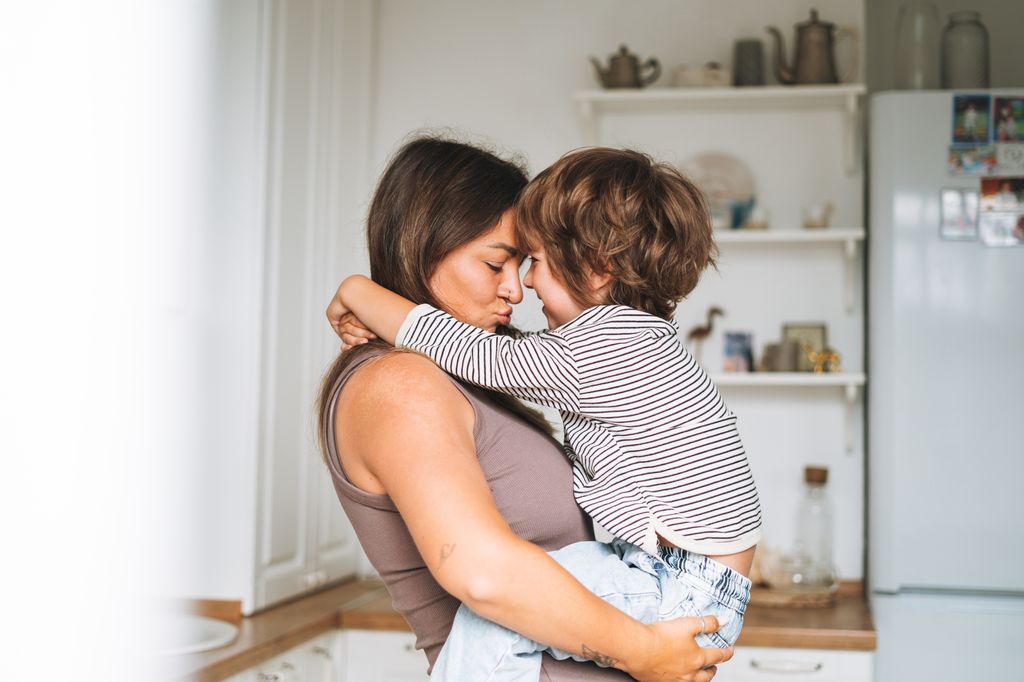 Madre sonriendo con su hijo en brazos