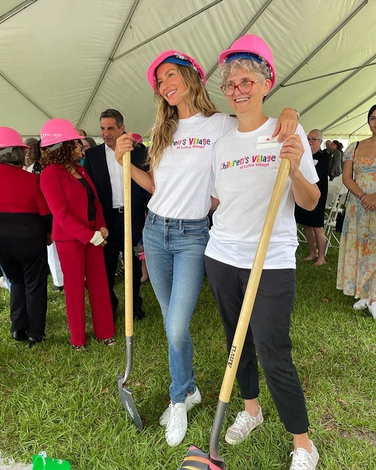Plano entero de Gisele Bündchen con Constance Collins posando con la camiseta de la fundación