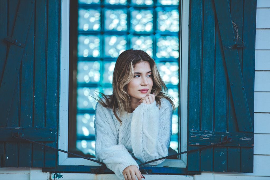 Mujer seria mira por la ventana