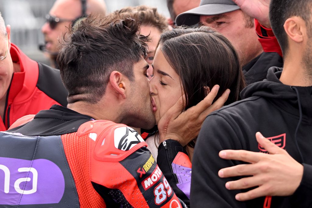 Beso de Jorge Martín con María Monfort tras su victoria en una carrera