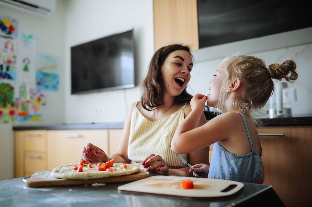 Madre e hija felices en la cocina