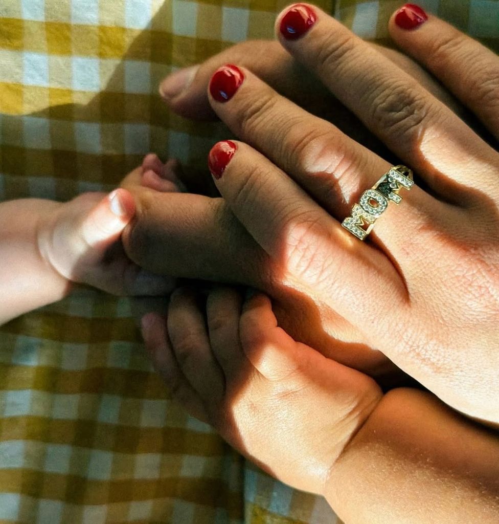 La pareja ha compartido la primera imagen de su nuevo bebé, en la que aparecen sus pequeñas manos junto a las de sus padres y un anillo con la palabra ‘MOM’