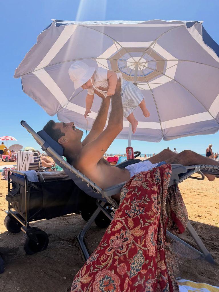 Padre e hijo protagonizan una de las imágenes más tiernas de estas vacaciones, jugando bajo una gran sombrilla durante una jornada de playa