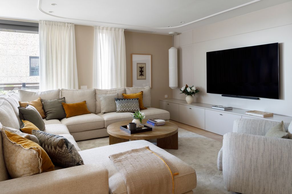 Salón con televisor en la pared frente al sofá
