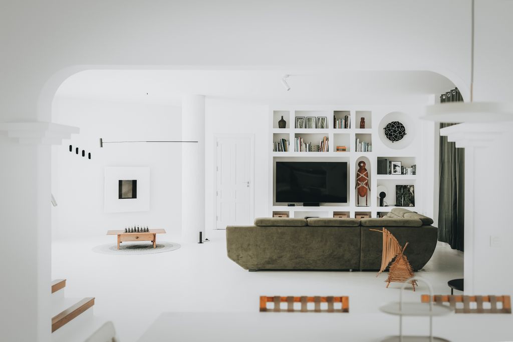 Salón de atmósfera minimalista con una cromática muy contenida a base de blancos y verdes
