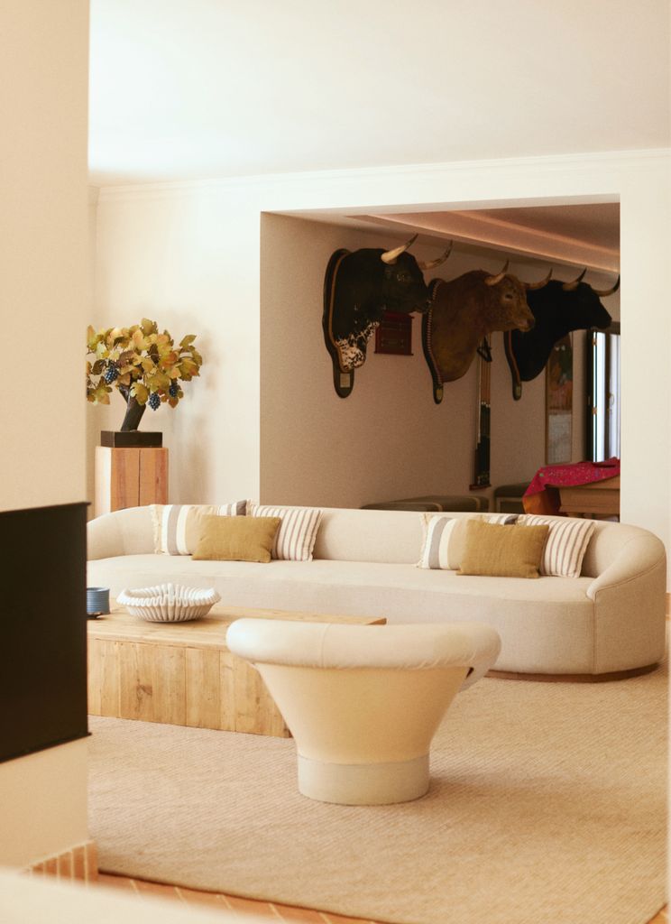 Un salón relajado en tonos neutros y con ornamentos taurinos en la pared 