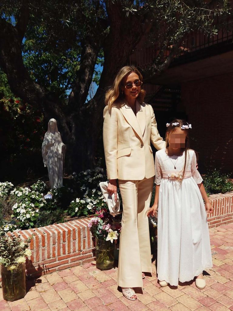 Carla Pereyra, con traje blanco, en la comunión de su hija con Diego Simeone en Madrid.