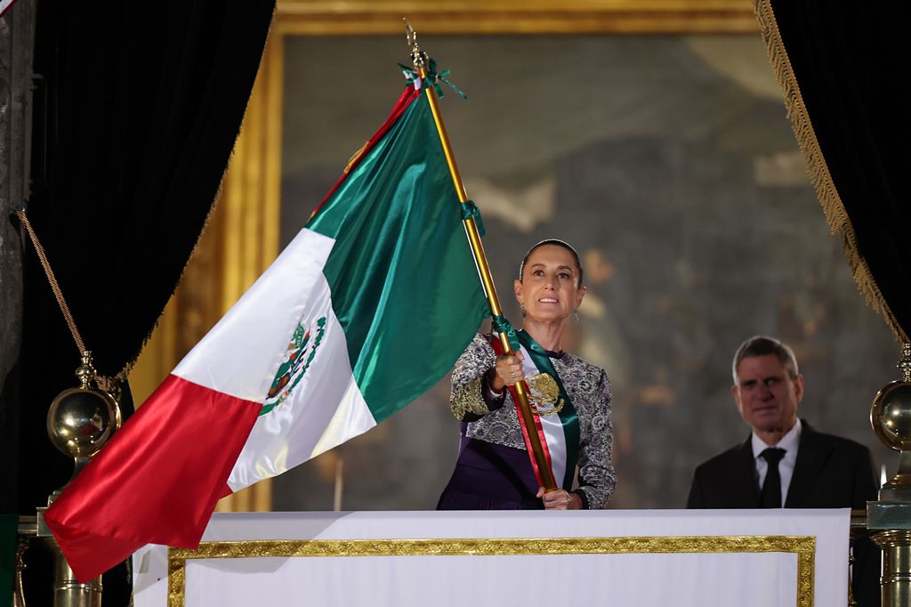 La presidenta de México, Claudia Sheinbaum, agitando la bandera de México.
