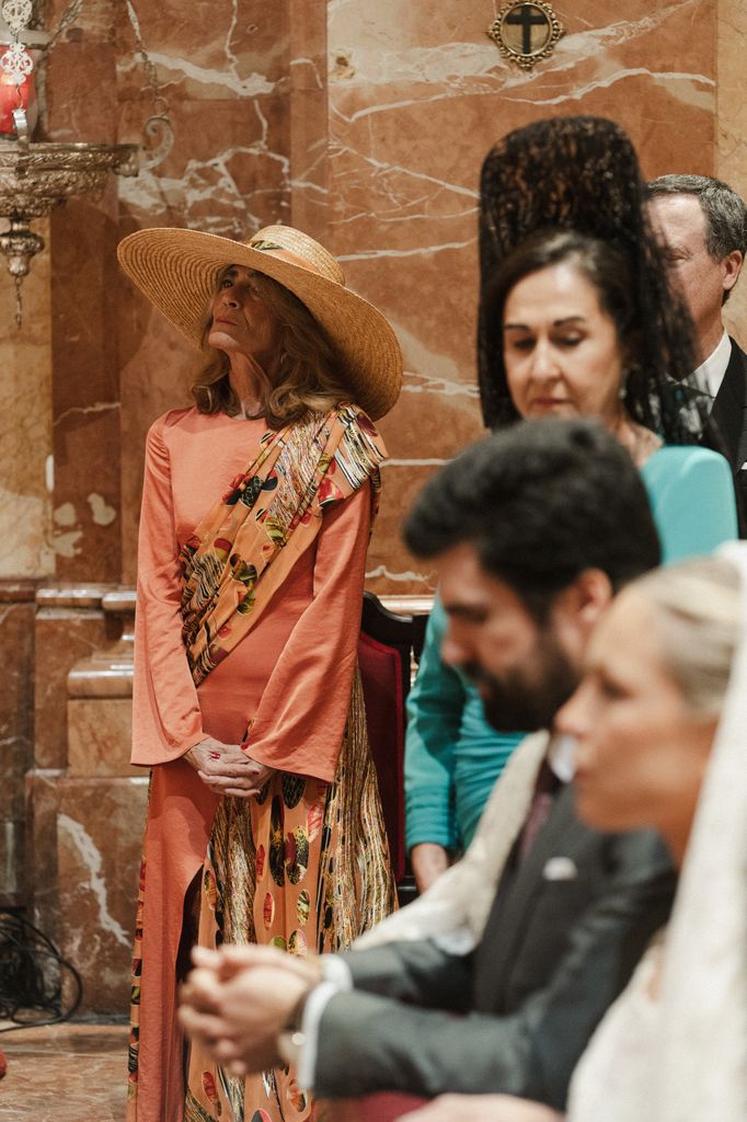Look de madre de la novia coral con pamela de rafia