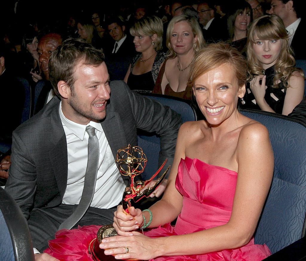Plano medio de Toni Collette y su marido tras haber recibido un premio Emmy