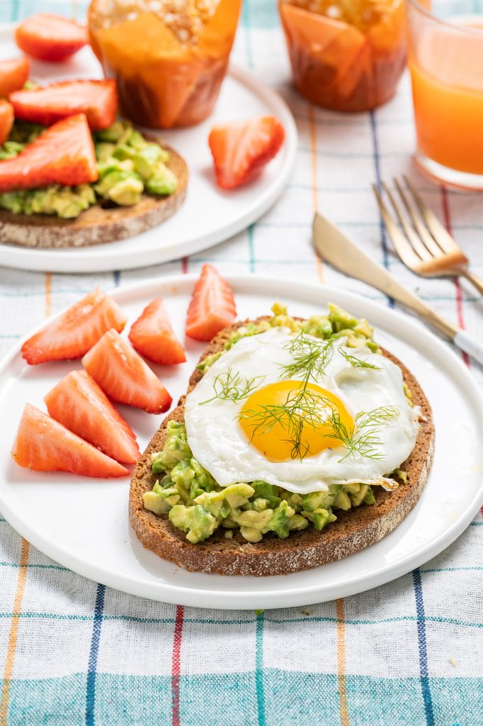 desayuno con tostadas de huevo y aguacate, fruta y zumo