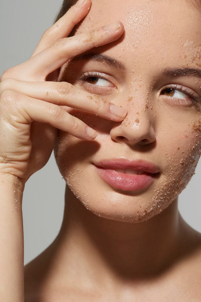 Rostro de mujer con exfoliante facial mirando hacia un lado