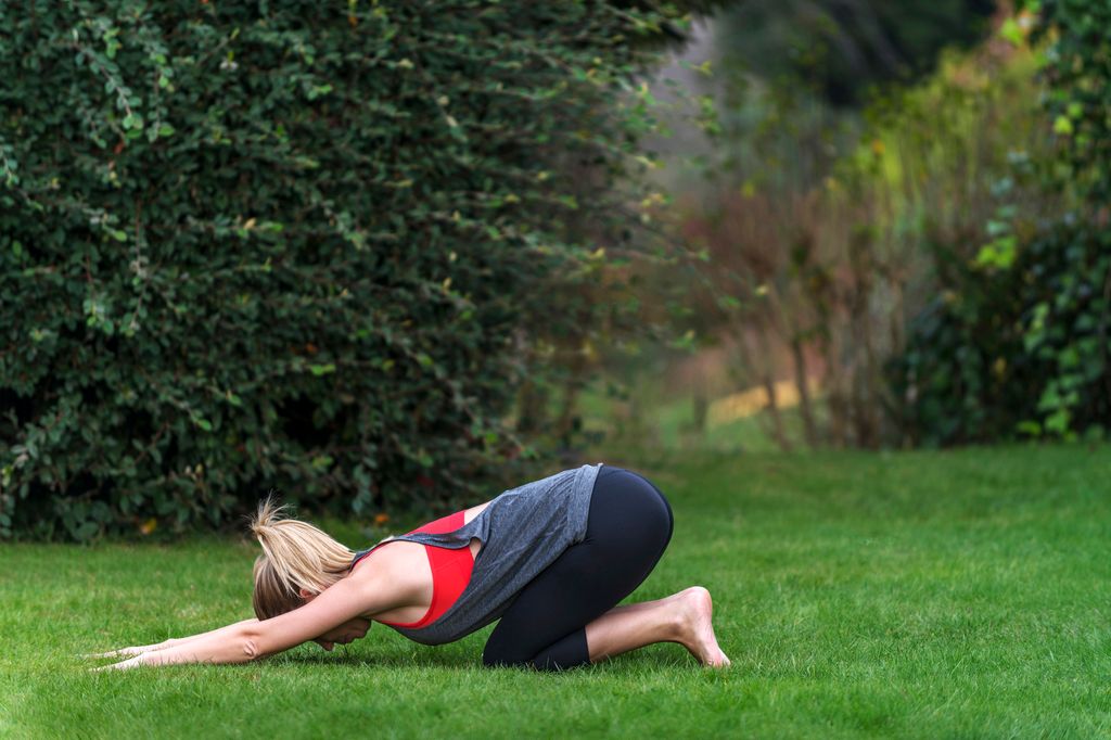 mujer haciendo la postura balasana de yoga