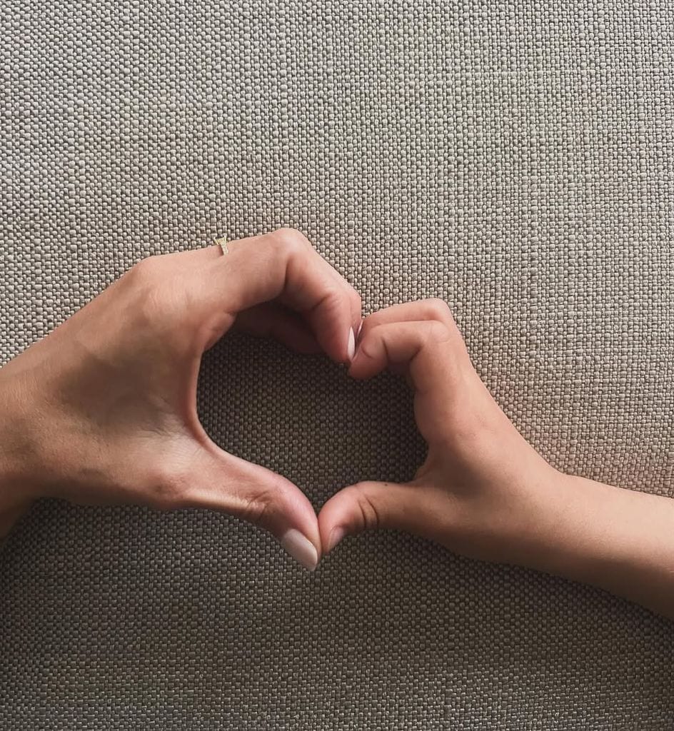 La periodista forma un corazón con la mano de su hijo