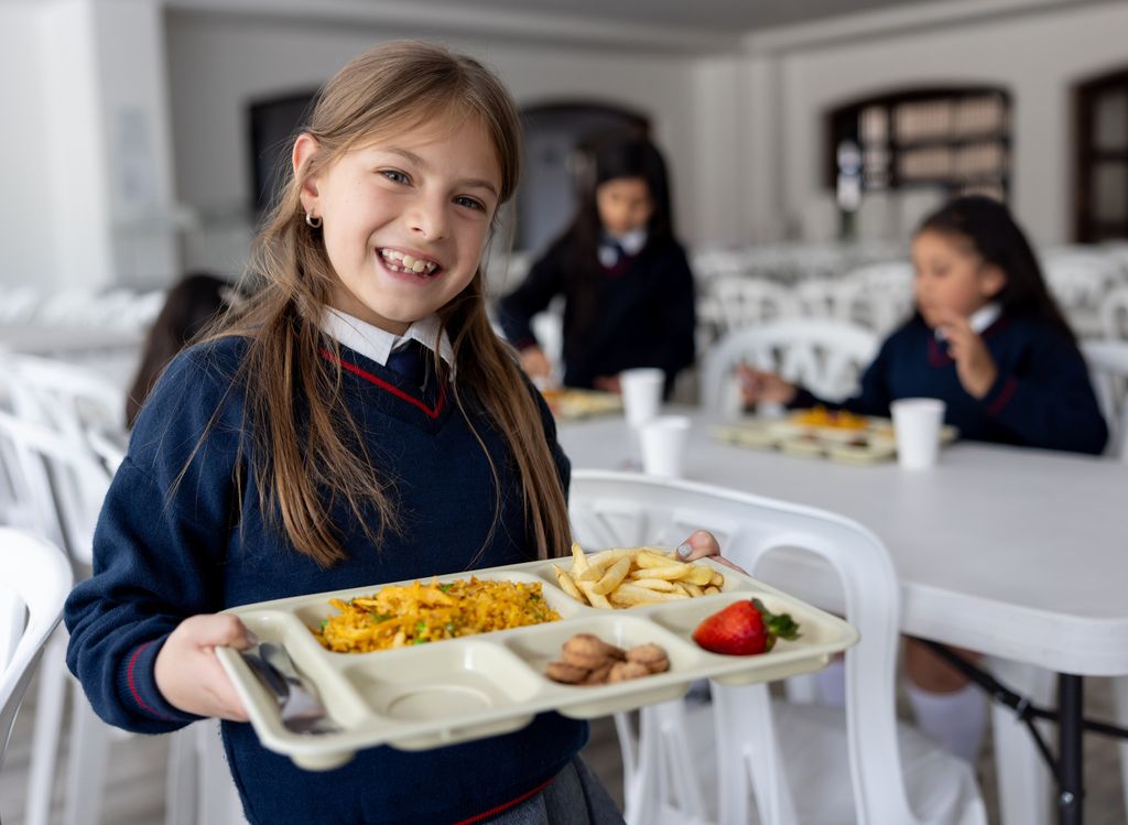 Niña en el comedo del colegio