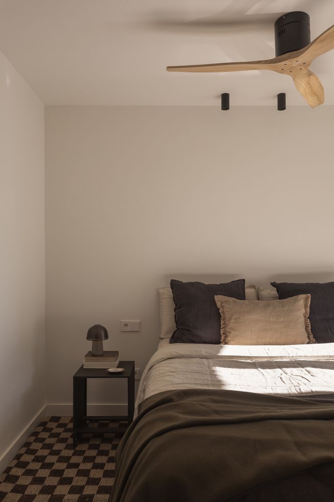 Dormitorio con la cama vestida con tejidos naturales