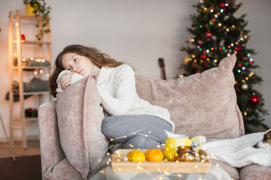mujer pensativa en el sofá en Navidad