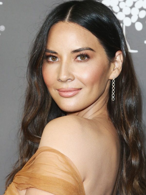 Olivia Munn en pose tres cuartos con vestido beige