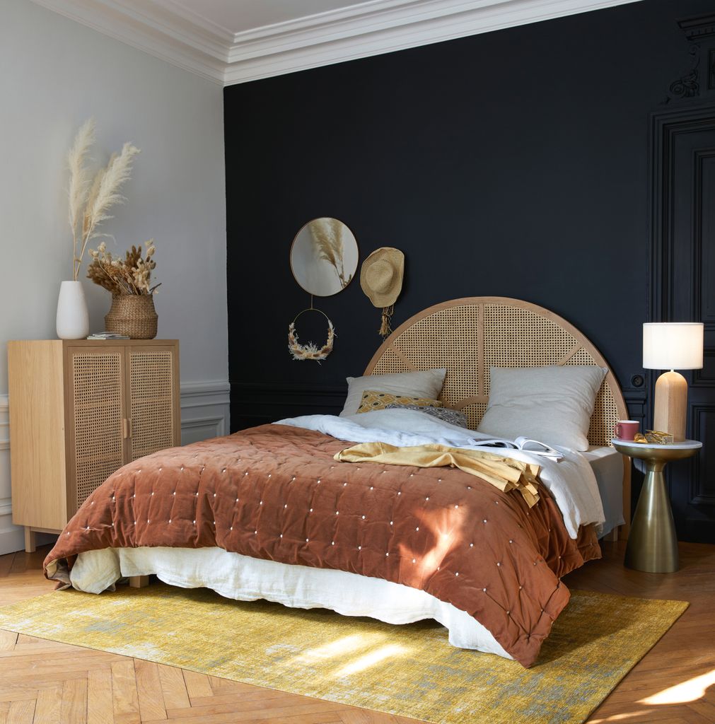 Dormitorio con muebles de ratán y mesilla metálica         