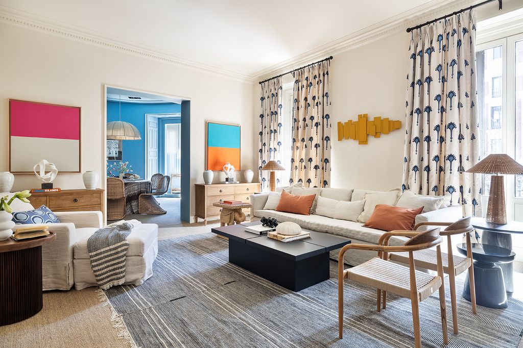 Salón con sofá blanco y sillones de madera