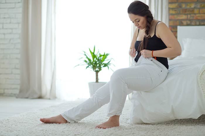 mujer abrochándose el pantalón