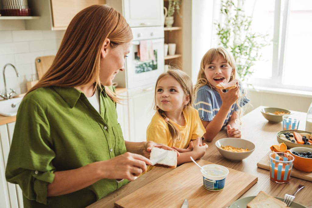 madre preparando la comida junto a sus hijas en la cocina