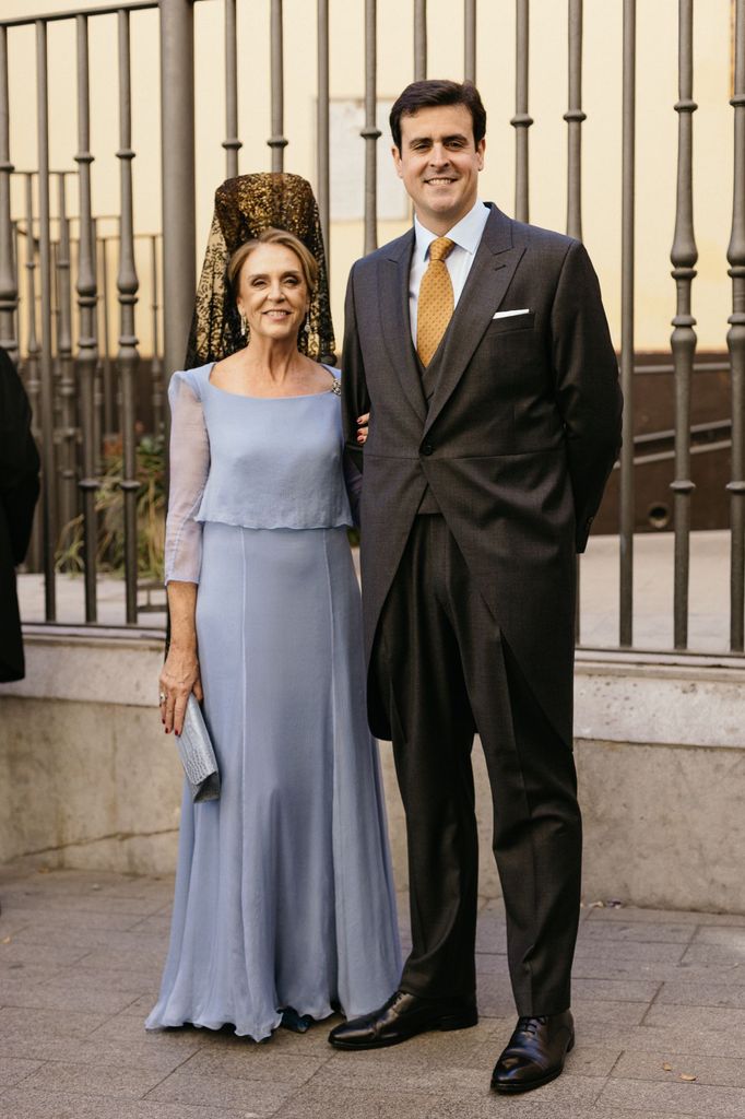 Madrina elegante de azul y mantilla en boda en Sevilla