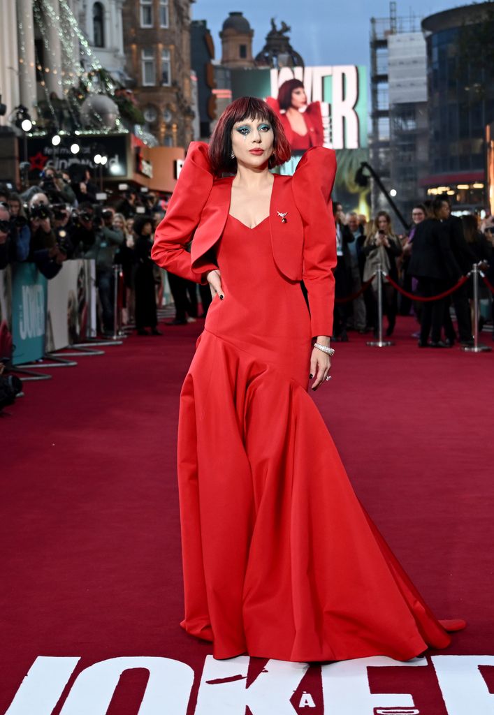 Plano entero de Lady Gaga con vestido con chaqueta de hombreras rojos