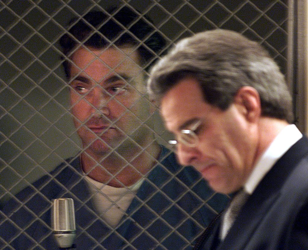 Andrew Luster, de 36 años, mira desde detrás de la valla metálica de la sala del tribunal que separa a los acusados del resto de la sala. Su abogado, Joel R. Isaacson, a la derecha, permanece a su lado durante la lectura de los cargos, en la que se declaró NO culpable de 40 cargos penales, entre ellos la violación de personas ebrias e inconscientes