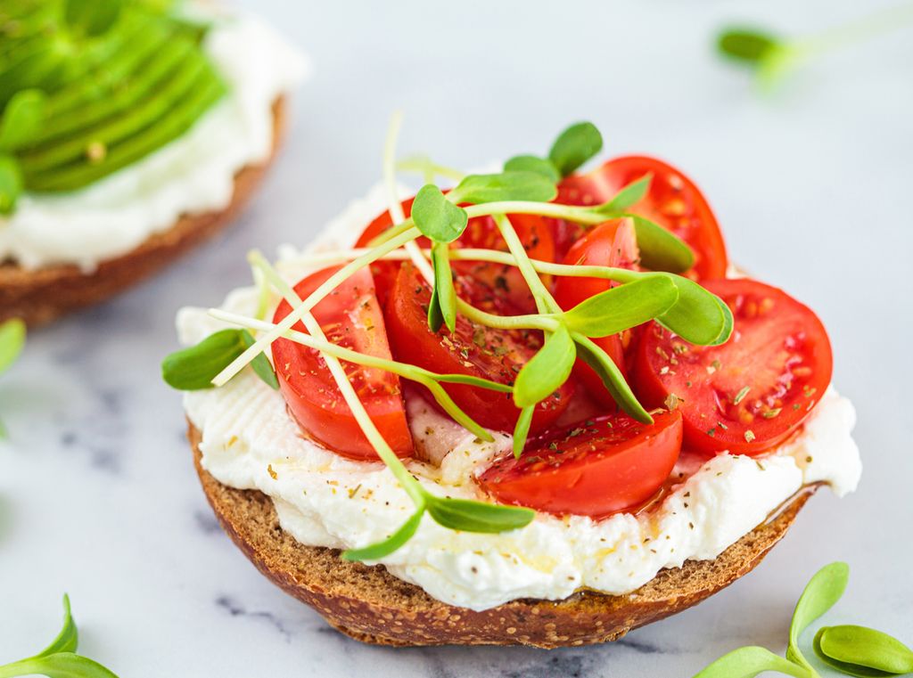 Tostada de pan integral, queso cremoso y tomates cherry: simple, sano y delicioso.