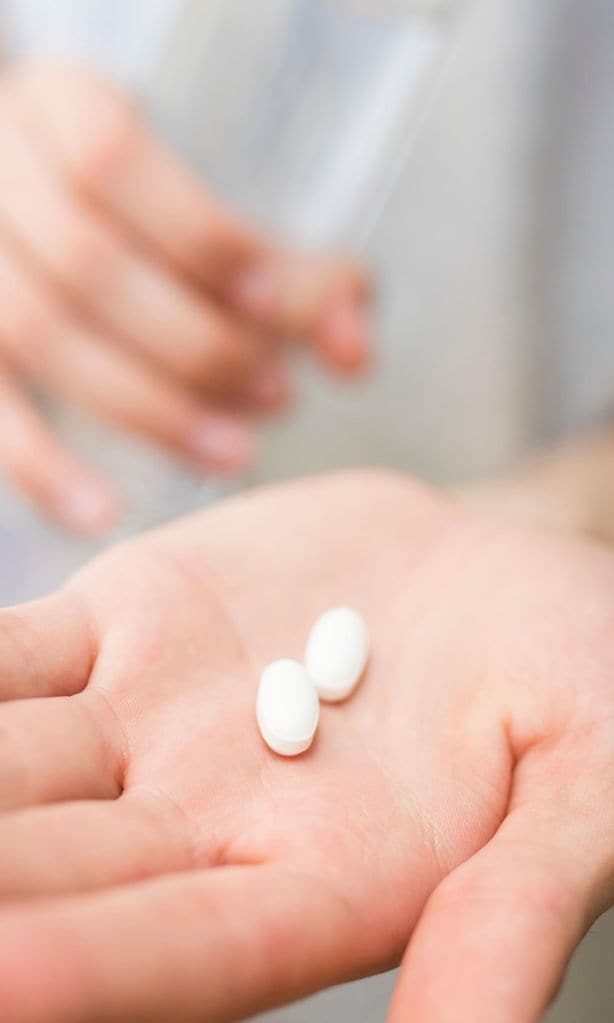Pastillas en la mano de una mujer