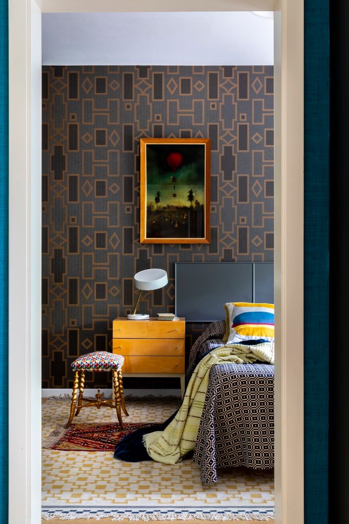 Dormitorio con papel pintado y cuadro. 