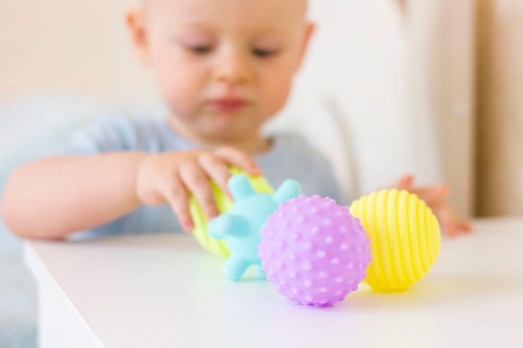 Bebé pequeño alineando juguetes