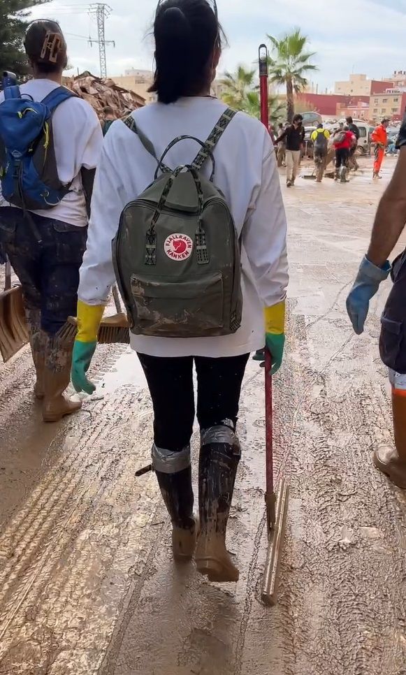 Plano entero de Aitana de espaldas en labores como voluntaria en Valencia