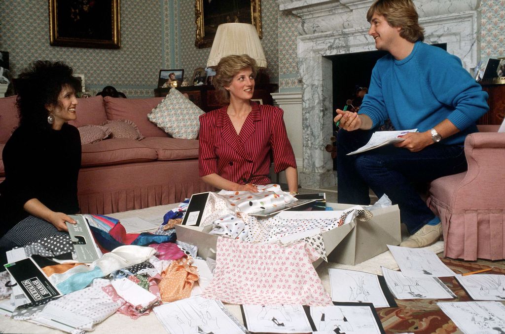 Plano medio de Diana de Gales hablando con David y Elizabeth Emanuel para el diseño de piezas de ropa