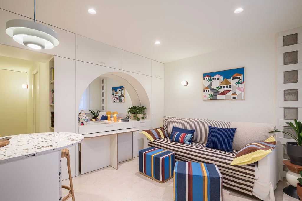 Salón con mueble a medida con espejos para guardar los puffs.  