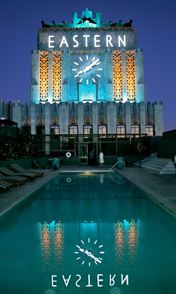 The Eastern Columbia\'s landmark clock tower is lighted every night, its newly restored facade refle