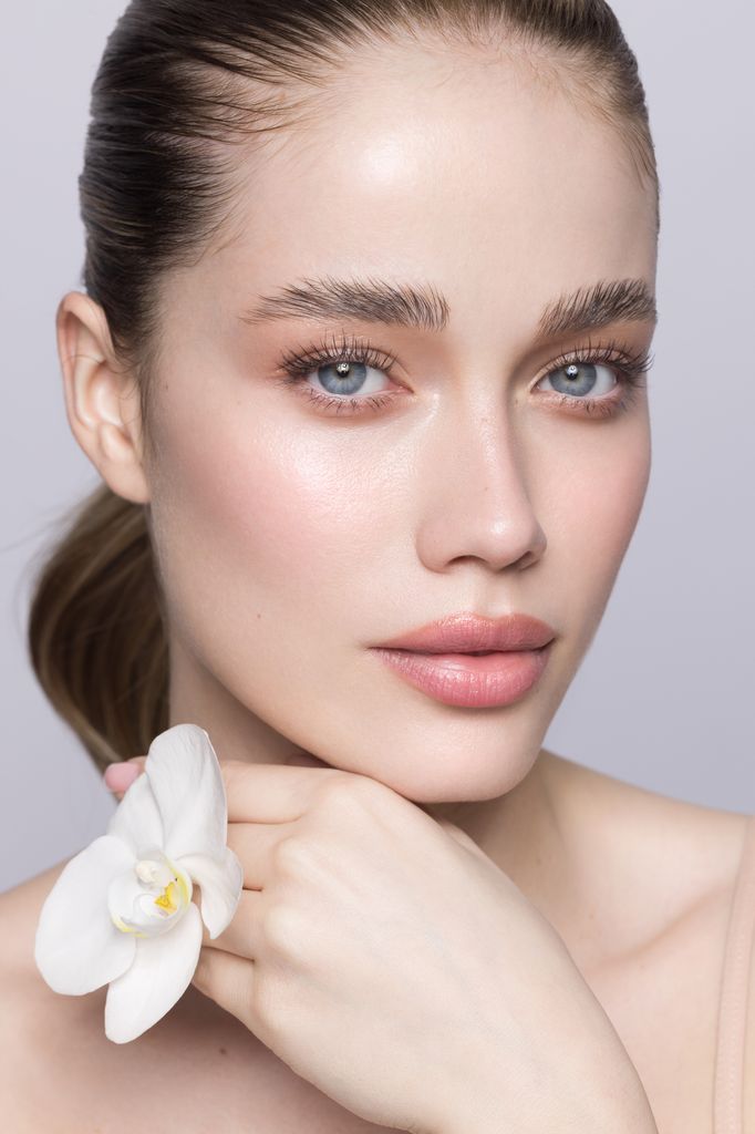 Mujer piel bonita con flor blanca en la mano