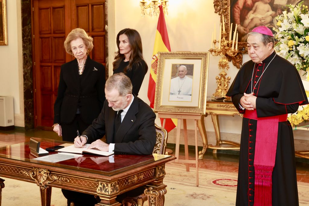 Los reyes Felipe y Letizia y la reina Sofía firmando en el libro de condolencias por el Papa Francisco 