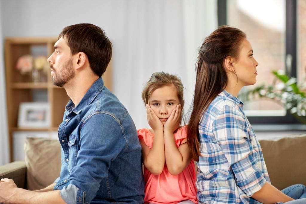 Padres de espaldas y en medio la hija en actitud de divorcio