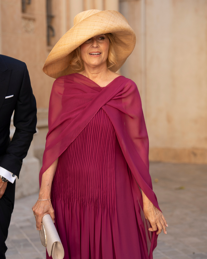 Madrina con vestido con capa y pamela